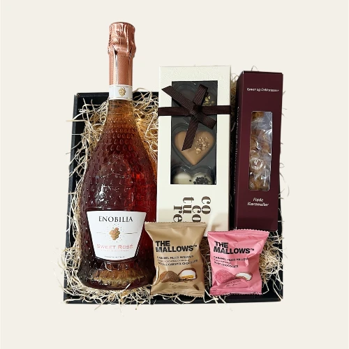 En gavekurv hvor man siger tak med sød rosè spumenta og søde delikatesser