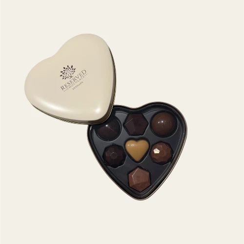 Elfenbensfarvet metaldåse med fyldte chokolader